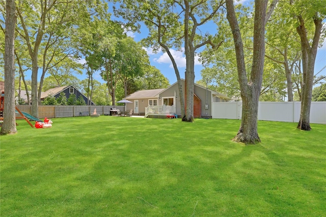 75 Lynncliff Rd, Hampton Bays, NY 11946 - fenced backyard featuring a playground and a wooden deck
