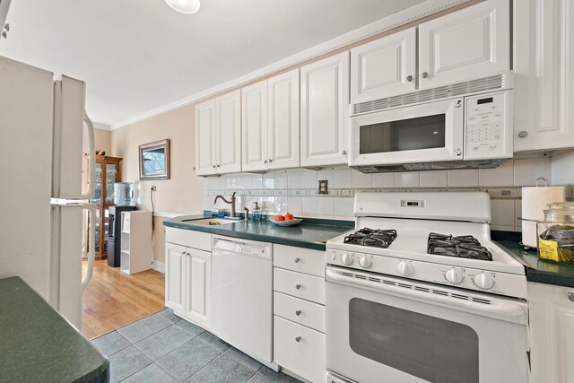 5730 Mosholu Ave Unit 4Ff, Bronx, NY 10471 - kitchen with white appliances, dark countertops, white cabinetry, tasteful backsplash, and crown molding