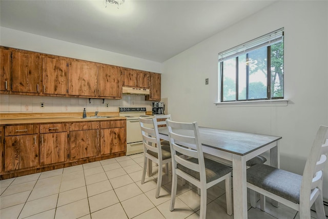 103 Lakeway Dr, West Babylon, NY 11704 - kitchen with white electric stove, under cabinet range hood, brown cabinetry, and backsplash