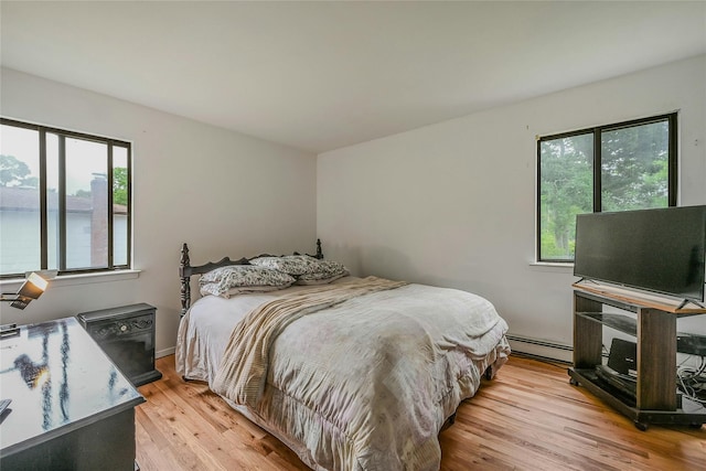 103 Lakeway Dr, West Babylon, NY 11704 - bedroom featuring multiple windows, light wood-style floors, and a baseboard radiator