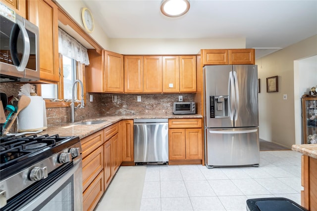 179 Alice Ave, Oceanside, NY 11572 - kitchen with appliances with stainless steel finishes, light stone counters, backsplash, and light tile patterned floors
