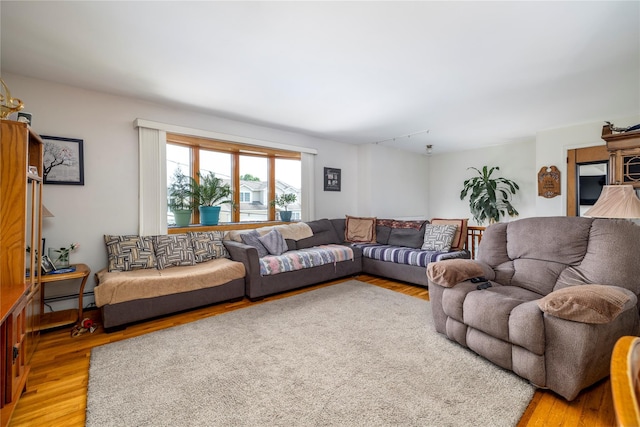 179 Alice Ave, Oceanside, NY 11572 - living room featuring light wood finished floors and a baseboard radiator