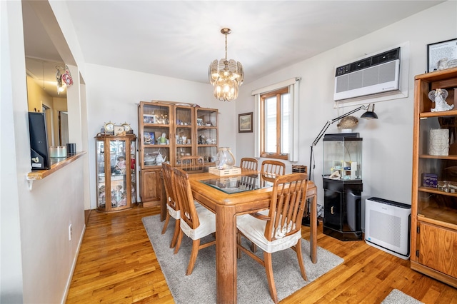 179 Alice Ave, Oceanside, NY 11572 - dining space featuring a wall mounted air conditioner, a chandelier, and light wood-style floors