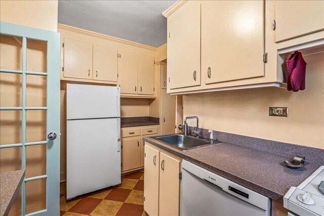 139-15 83rd Ave Unit 520, Briarwood, NY 11435 - kitchen featuring freestanding refrigerator, dishwashing machine, cream cabinetry, tile patterned floors, and dark countertops