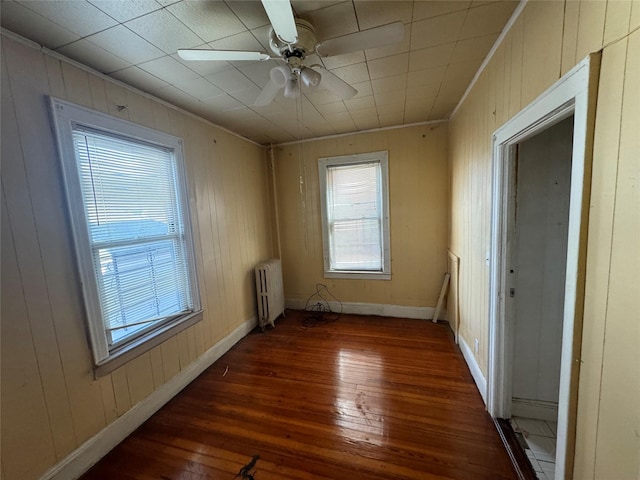 107-03 32nd Ave, East Elmhurst, NY 11369 - empty room featuring hardwood / wood-style flooring, radiator heating unit, wooden walls, ceiling fan, and crown molding