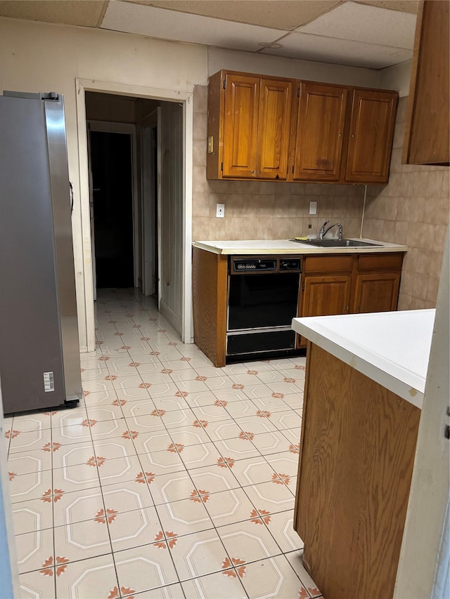 107-03 32nd Ave, East Elmhurst, NY 11369 - kitchen with black dishwasher, brown cabinets, light countertops, a paneled ceiling, and light flooring