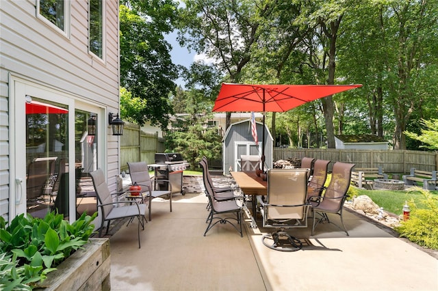 22 Woodchuck Ln, East Setauket, NY 11733 - fenced backyard with outdoor dining area, a shed, a patio, and an outdoor fire pit