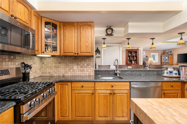 22 Woodchuck Ln, East Setauket, NY 11733 - kitchen featuring stainless steel appliances, glass insert cabinets, backsplash, and brown cabinetry