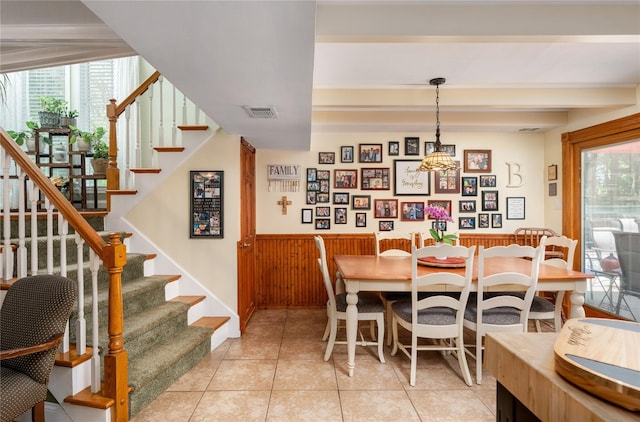 22 Woodchuck Ln, East Setauket, NY 11733 - dining space with stairs, a wainscoted wall, healthy amount of natural light, a chandelier, and light tile patterned floors