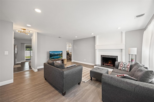 16 Melvin Ave, Farmingville, NY 11738 - living room featuring light wood-style floors, recessed lighting, and a warm lit fireplace