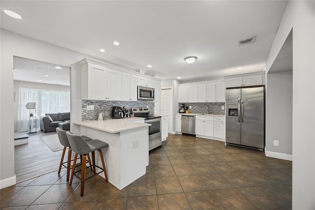 16 Melvin Ave, Farmingville, NY 11738 - kitchen with appliances with stainless steel finishes, a peninsula, decorative backsplash, light countertops, and recessed lighting