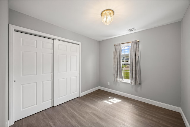 16 Melvin Ave, Farmingville, NY 11738 - unfurnished bedroom with wood finished floors, a closet, and a chandelier