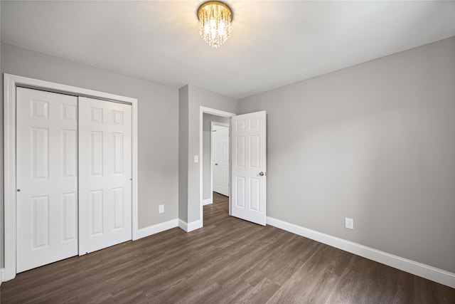 16 Melvin Ave, Farmingville, NY 11738 - unfurnished bedroom featuring dark wood finished floors, a chandelier, and a closet