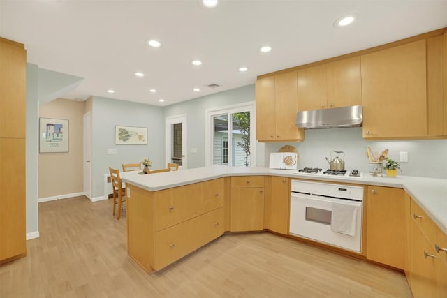 294 Colonel Greene Rd, Yorktown Heights, NY 10598 - kitchen featuring white appliances, a peninsula, under cabinet range hood, light countertops, and light wood-type flooring