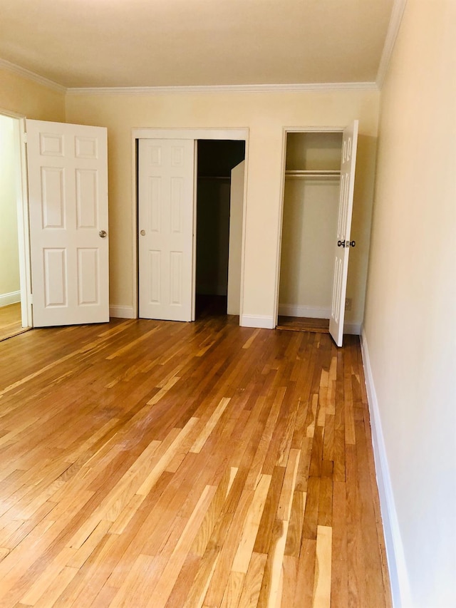 1296 Midland Ave Unit A3, Yonkers, NY 10704 - unfurnished bedroom featuring two closets, light wood finished floors, and crown molding