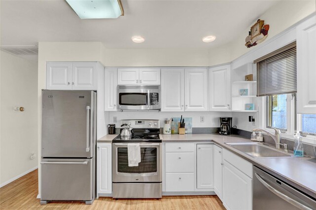 138 Sequams Ln E, West Islip, NY 11795 - kitchen with appliances with stainless steel finishes, light wood-style floors, white cabinetry, and light countertops