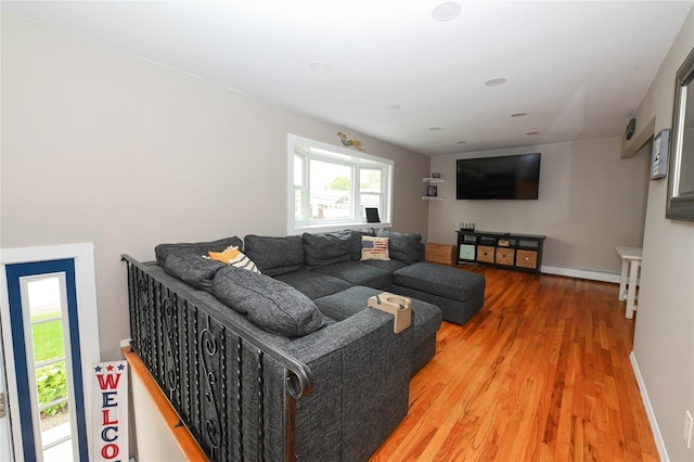 184 Sumpwams Ave, Babylon, NY 11702 - living area with light wood-style flooring and a baseboard heating unit