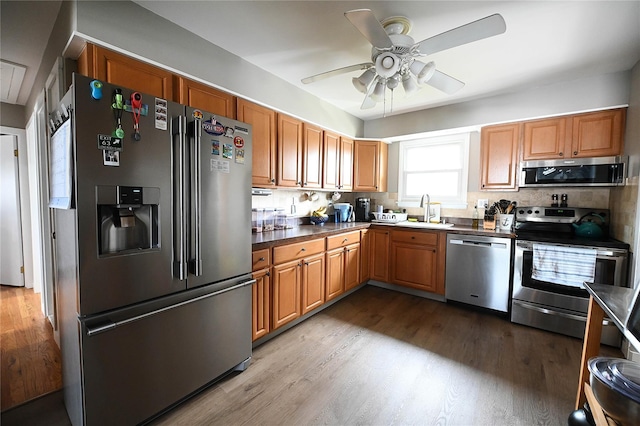 184 Sumpwams Ave, Babylon, NY 11702 - kitchen featuring stainless steel appliances, ceiling fan, wood finished floors, dark countertops, and brown cabinets