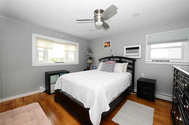 184 Sumpwams Ave, Babylon, NY 11702 - bedroom with a wall mounted air conditioner, multiple windows, a baseboard radiator, and wood finished floors