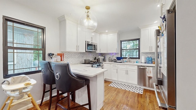 17 Arthur Pl, Yonkers, NY 10701 - kitchen featuring appliances with stainless steel finishes, a peninsula, white cabinets, and recessed lighting