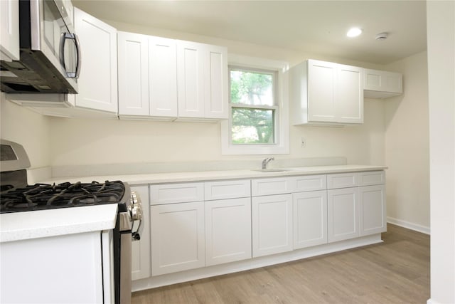 24 Parsons Dr, Hempstead, NY 11550 - kitchen with appliances with stainless steel finishes, white cabinetry, light wood-type flooring, and recessed lighting