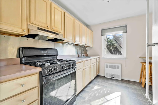 29-49 137th St Unit 2H, Flushing, NY 11354 - kitchen with black gas stove, radiator, under cabinet range hood, light countertops, and light brown cabinets
