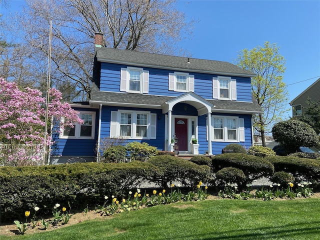 3665 Lufberry Ave, Wantagh, NY 11793 - view of front of house featuring a chimney, a front yard, and a shingled roof
