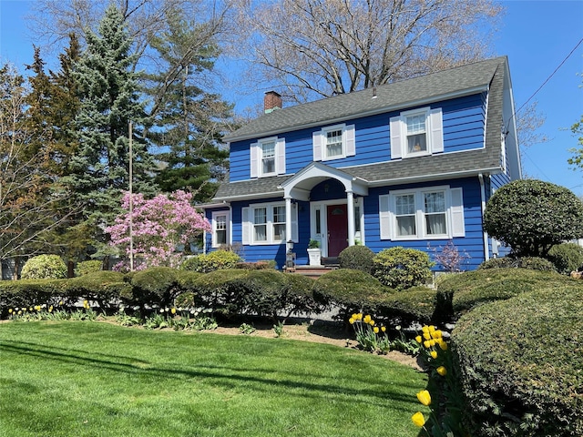 3665 Lufberry Ave, Wantagh, NY 11793 - view of front of home with a front yard, a chimney, and a shingled roof