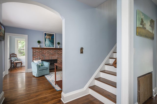 3665 Lufberry Ave, Wantagh, NY 11793 - stairway with wood finished floors, arched walkways, radiator, and a brick fireplace