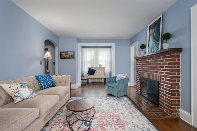 3665 Lufberry Ave, Wantagh, NY 11793 - living room featuring a fireplace, wood finished floors, and arched walkways