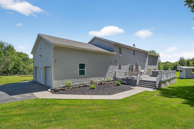 97 Pittaluga Dr, Monticello, NY 12701 - back of property with asphalt driveway, a deck, a garage, and a lawn