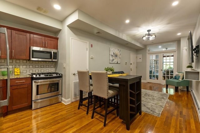 100 Ralph Ave Unit 2L, Brooklyn, NY 11221 - kitchen featuring stainless steel appliances, wood finished floors, tasteful backsplash, and recessed lighting