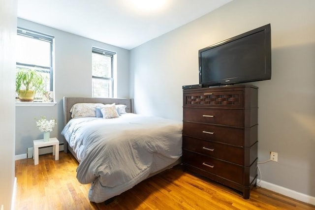100 Ralph Ave Unit 2L, Brooklyn, NY 11221 - bedroom featuring a baseboard heating unit and wood finished floors