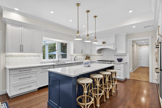 8 Danton Ln S, Locust Valley, NY 11560 - kitchen featuring white cabinets, a breakfast bar area, dark wood finished floors, a kitchen island, and light countertops