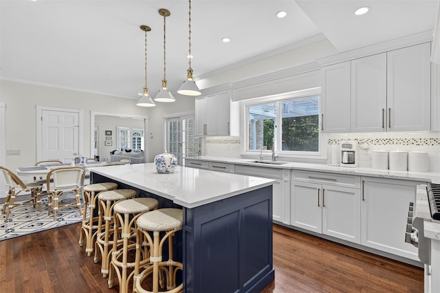 8 Danton Ln S, Locust Valley, NY 11560 - kitchen with crown molding, white cabinetry, tasteful backsplash, a kitchen island, and a kitchen breakfast bar
