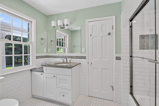 8 Danton Ln S, Locust Valley, NY 11560 - bathroom with tile walls, wainscoting, vanity, enclosed tub / shower combo, and tile patterned floors