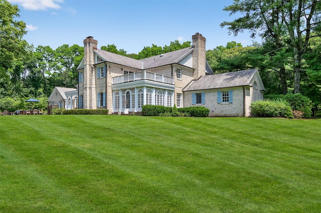 8 Danton Ln S, Locust Valley, NY 11560 - back of property with a balcony, a chimney, a yard, and brick siding