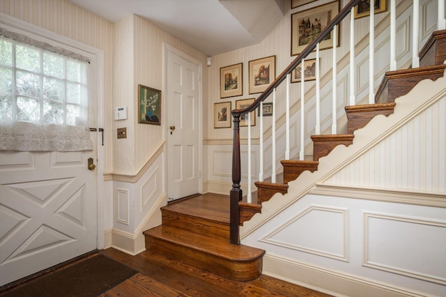 38 Mason Dr, Manhasset, NY 11030 - entryway featuring dark wood finished floors, a decorative wall, wallpapered walls, stairs, and wainscoting