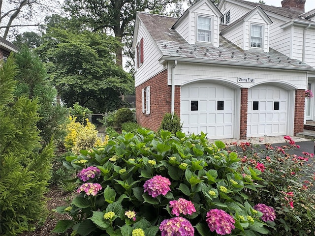 38 Mason Dr, Manhasset, NY 11030 - view of side of property with brick siding, a chimney, and a garage