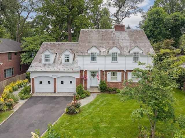 38 Mason Dr, Manhasset, NY 11030 - view of front of home with brick siding, a chimney, driveway, a front yard, and a garage