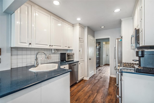 58 Circle Dr, Syosset, NY 11791 - kitchen featuring appliances with stainless steel finishes, dark countertops, white cabinetry, dark wood-style floors, and backsplash