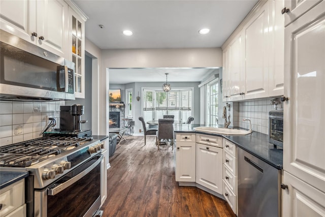 58 Circle Dr, Syosset, NY 11791 - kitchen with appliances with stainless steel finishes, dark countertops, white cabinetry, and recessed lighting