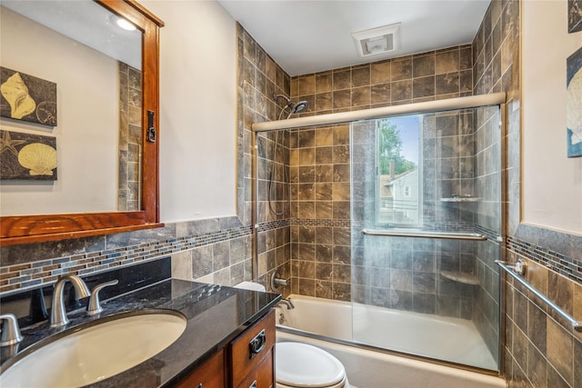 58 Circle Dr, Syosset, NY 11791 - full bathroom with tile walls, vanity, bath / shower combo with glass door, and wainscoting