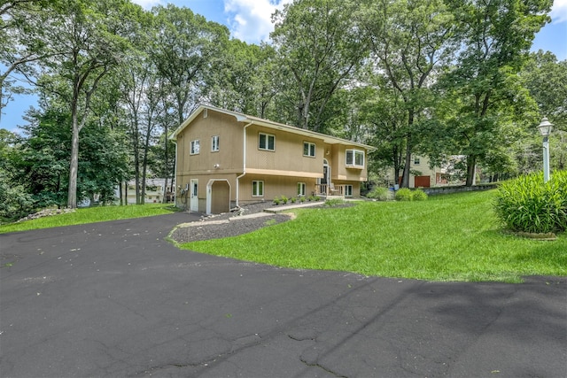 17 Onderdonk Rd, Suffern, NY 10901 - view of front of property featuring an attached garage, asphalt driveway, a front yard, and view of wooded area