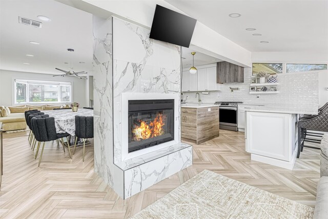 17 Onderdonk Rd, Suffern, NY 10901 - kitchen with electric stove, light countertops, a kitchen bar, open floor plan, and a high end fireplace