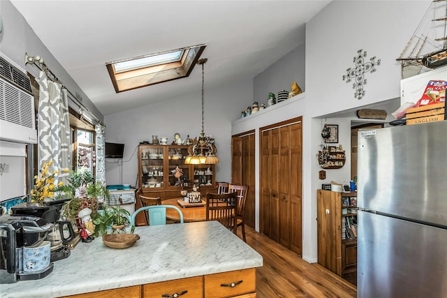 20 Wensley Rd, Plainview, NY 11803 - kitchen featuring freestanding refrigerator, a skylight, wood finished floors, and lofted ceiling