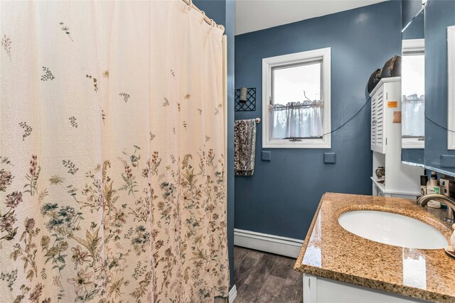20 Wensley Rd, Plainview, NY 11803 - full bathroom featuring a baseboard heating unit, vanity, wood finished floors, and curtained shower