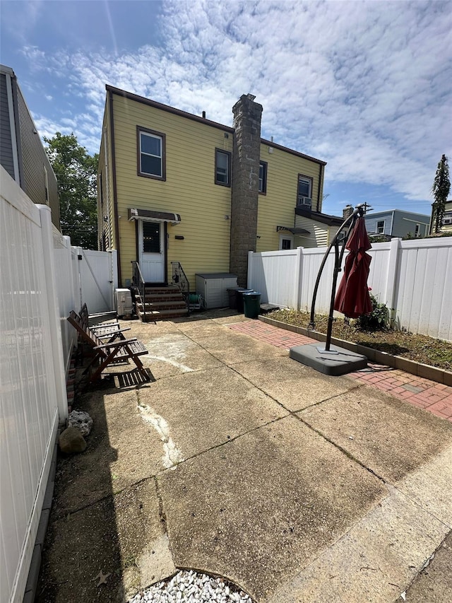 33-13 202nd St, Bayside, NY 11361 - back of property with entry steps, a patio area, and a fenced backyard