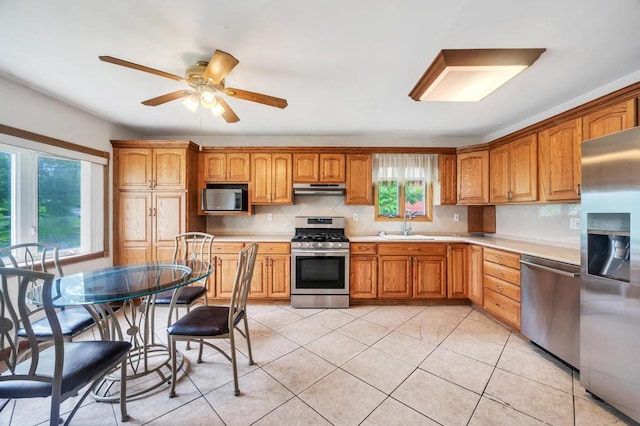 3 Washington Ave, Selden, NY 11784 - kitchen featuring appliances with stainless steel finishes, light countertops, decorative backsplash, under cabinet range hood, and ceiling fan