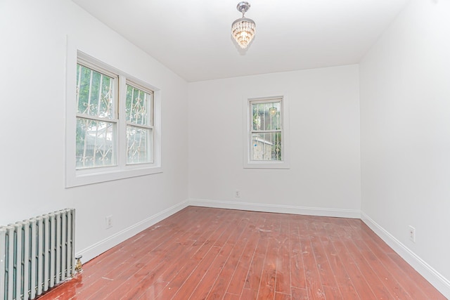 592 E 39th St, Brooklyn, NY 11203 - spare room with radiator heating unit, plenty of natural light, and hardwood / wood-style flooring
